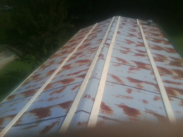 Rusted metal roof panels with new wood purlins before replacement — Storm Damage Roof Repair in Twin Valley by Roofing Brothers