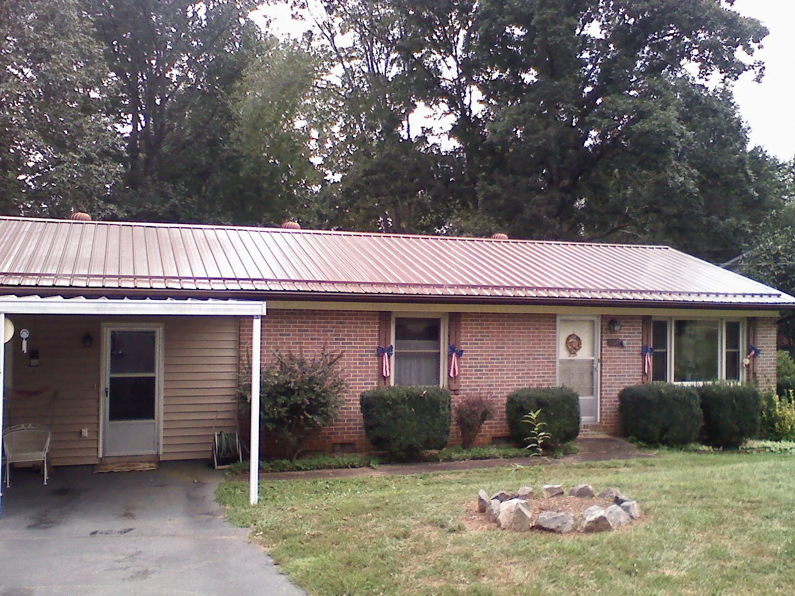 Bronze metal roof and carport on a brick ranch home — Roof Repair work by our crew in Twin Valley